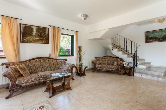 Open-plan living room with sofas, dining area, kitchen, ornamental fireplace, A/C, WiFi internet, satellite TV, and terrace access . - Androula Villas Collection . (Galería de imágenes) }}