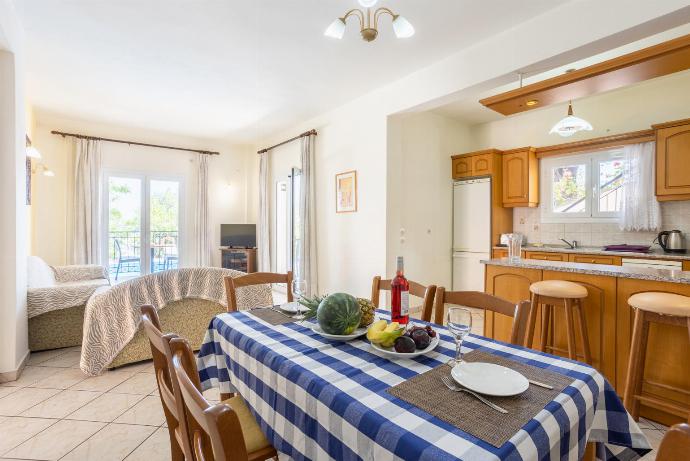 Open-plan living room with sofas, dining area, kitchen WiFi internet, TV, and terrace access . - Nissaki Villas Collection . (Galerie de photos) }}