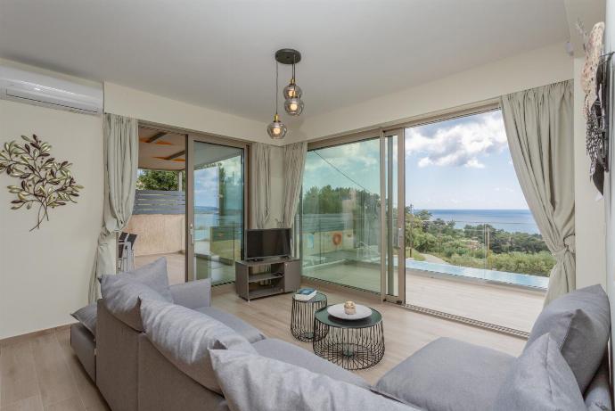 Open-plan living room with sofas, dining area, kitchen, A/C, WiFi internet, satellite TV, and terrace access . - Lassi Villas Collection . (Galleria fotografica) }}