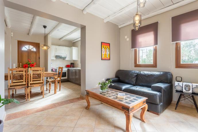 Open-plan living room with sofas, dining area, kitchen, ornamental fireplace, WiFi internet, satellite TV, DVD player, and terrace access  . - Neria Villas Collection . (Galerie de photos) }}