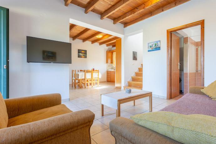 Open-plan living room with sofas, dining area, kitchen, A/C, WiFi internet, satellite TV, DVD player, and terrace access . - Spiros Villas Collection . (Fotogalerie) }}