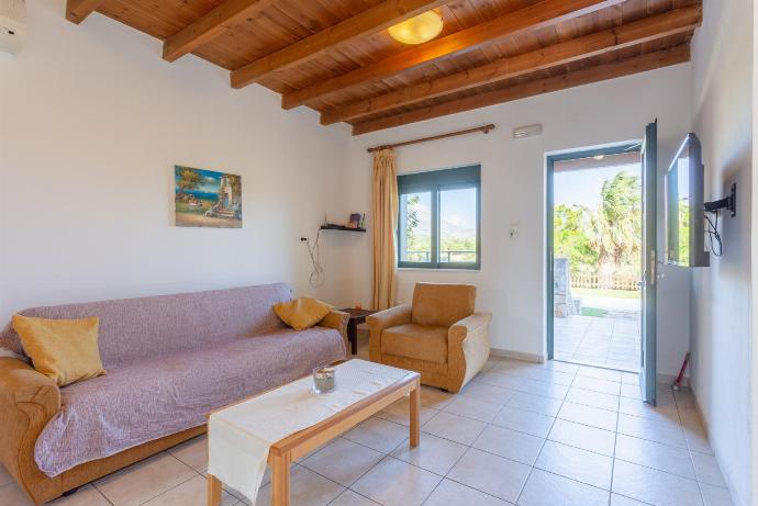 Open-plan living room with sofas, dining area, kitchen, A/C, WiFi internet, satellite TV, DVD player, and terrace access . - Spiros Villas Collection . (Galería de imágenes) }}