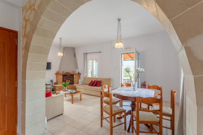 Open-plan living room with sofas, dining area, kitchen, ornamental fireplace, A/C, WiFi internet, TV, DVD player, and terrace access . - Kalyves Villas Collection . (Galería de imágenes) }}