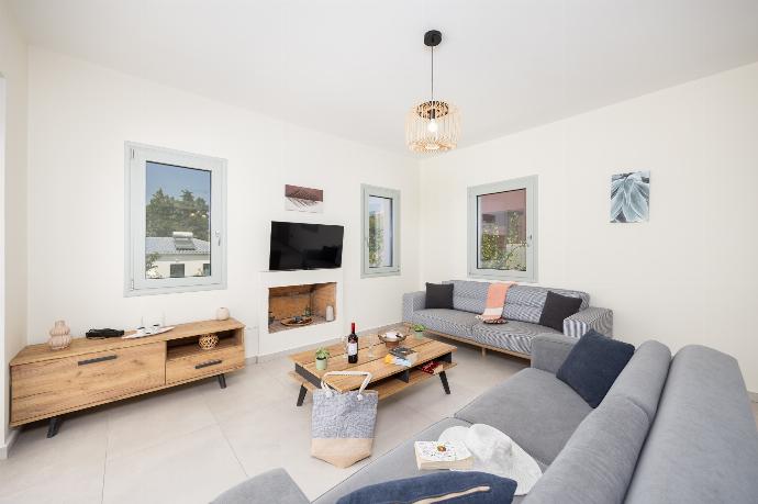 Open-plan living room with sofas, dining area, kitchen, ornamental fireplace, A/C, WiFi internet, and satellite TV . - Villa Kira . (Photo Gallery) }}