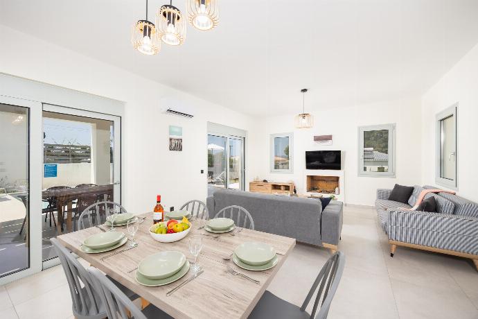 Open-plan living room with sofas, dining area, kitchen, ornamental fireplace, A/C, WiFi internet, and satellite TV . - Villa Kira . (Photo Gallery) }}