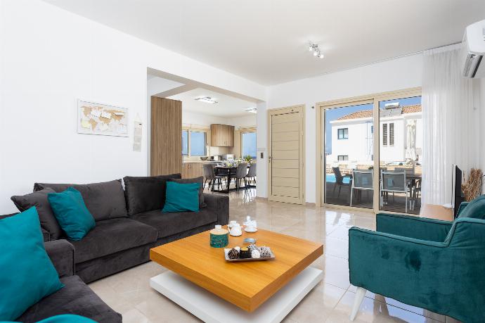 Open-plan living room with sofas, dining area, kitchen, A/C, WiFi internet, satellite TV, and sea views . - Villa Diana Seaside . (Photo Gallery) }}