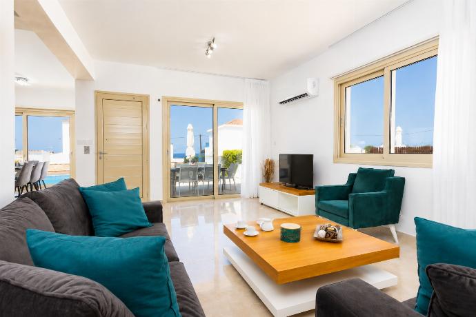 Open-plan living room with sofas, dining area, kitchen, A/C, WiFi internet, satellite TV, and sea views . - Villa Diana Seaside . (Γκαλερί Φωτογραφιών) }}