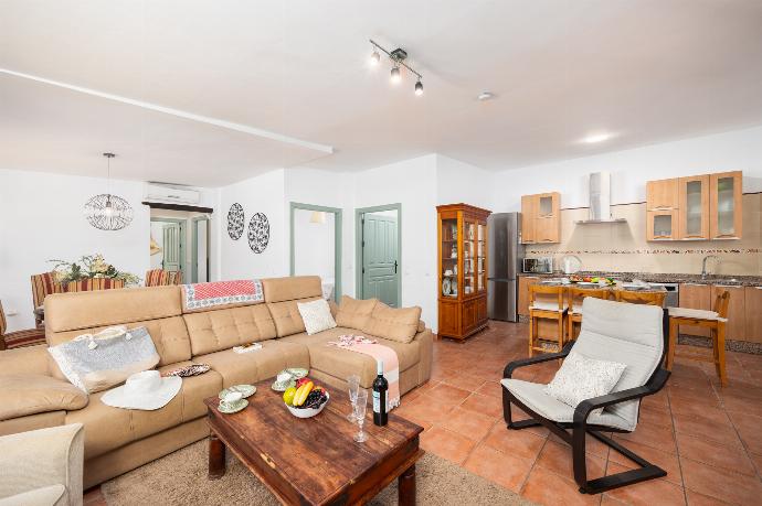 Open-plan living room with sofa, dining area, kitchen, ornamental fireplace, A/C, WiFi internet, and satellite TV . - Villa Tinao . (Photo Gallery) }}