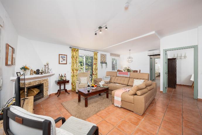 Open-plan living room with sofa, dining area, kitchen, ornamental fireplace, A/C, WiFi internet, and satellite TV . - Villa Tinao . (Photo Gallery) }}