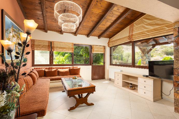 Open-plan living room with sofas, dining area, kitchen, ornamental fireplace, A/C, WiFi internet, and satellite TV . - Villa Elounda Blue . (Photo Gallery) }}