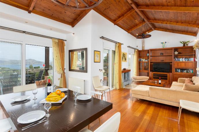 Open-plan living room with sofa, dining area, kitchen, A/C, WiFi internet, satellite TV, and sea views . - Villa Glan Y Mor . (Photo Gallery) }}