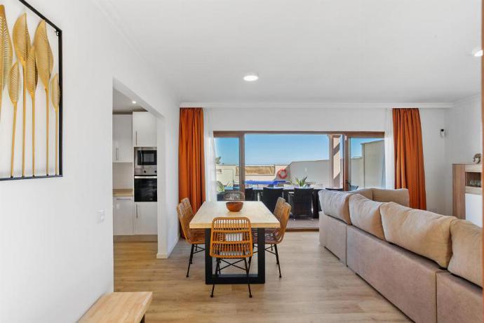 Open-plan living room with sofas, dining area, kitchen, ornamental fireplace, A/C, WiFi internet, satellite TV, and terrace access with panoramic view . - Villa Mariposas Caleta . (Fotogalerie) }}