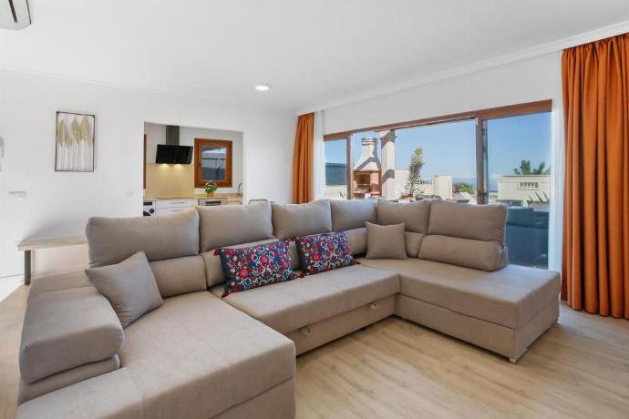 Open-plan living room with sofas, dining area, kitchen, ornamental fireplace, A/C, WiFi internet, satellite TV, and terrace access with panoramic view . - Villa Mariposas Caleta . (Fotogalerie) }}