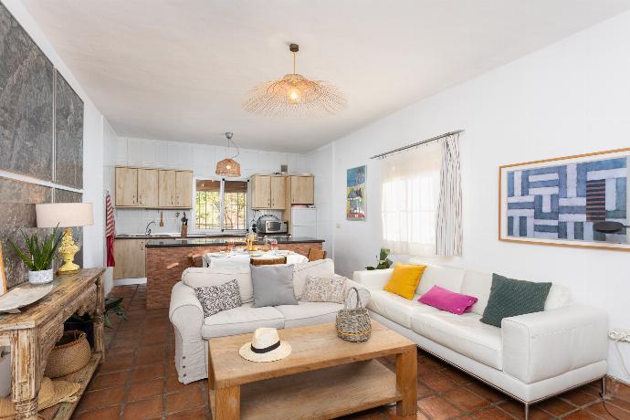 Open-plan living room with sofas, dining area, kitchen, ornamental fireplace, A/C, WiFi internet, and satellite TV . - Villa La Higuera . (Photo Gallery) }}