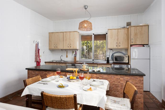 Open-plan living room with sofas, dining area, kitchen, ornamental fireplace, A/C, WiFi internet, and satellite TV . - Villa La Higuera . (Photo Gallery) }}