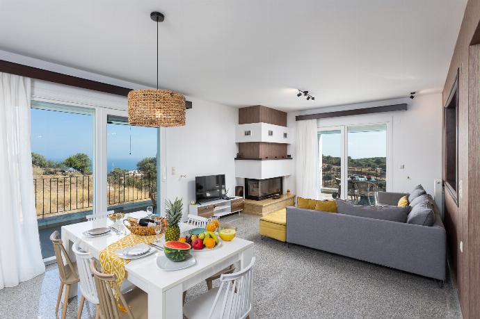 Open-plan living room with sofa, dining area, kitchen, ornamental fireplace, WiFi internet, satellite TV, and sea views . - Villa Sonata . (Photo Gallery) }}
