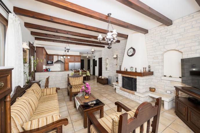 Open-plan living room with sofa, dining area, kitchen, ornamental fireplace, A/C, WiFi internet, satellite TV, and sea views . - Villa Ariadne . (Photo Gallery) }}