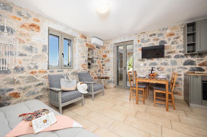 Open-plan living room with sofa, dining area, kitchen, A/C, WiFi internet, and satellite TV . - Villa Dioni Tria . (Photo Gallery) }}