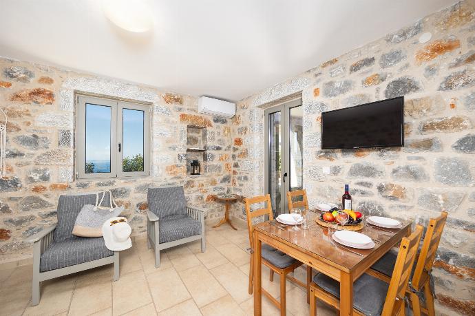 Open-plan living room with sofa, dining area, kitchen, A/C, WiFi internet, and satellite TV . - Villa Dioni Tria . (Photo Gallery) }}