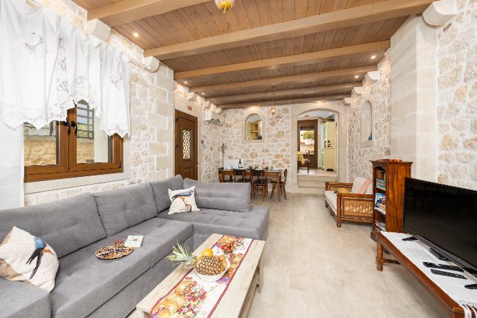 Living room with sofa, dining area, ornamental fireplace, A/C, WiFi internet, and satellite TV . - Villa Koupos . (Photo Gallery) }}