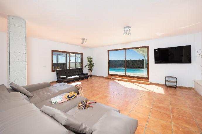Living area with sofa, dining area, kitchenette, satellite TV, and sea views . - Villa Asomada . (Photo Gallery) }}