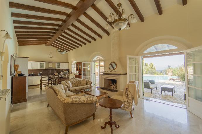 Open-plan living room with sofas, dining area, kitchen, ornamental fireplace, WiFi internet, satellite TV, and terrace access with panoramic sea views . - Villa Emily . (Fotogalerie) }}