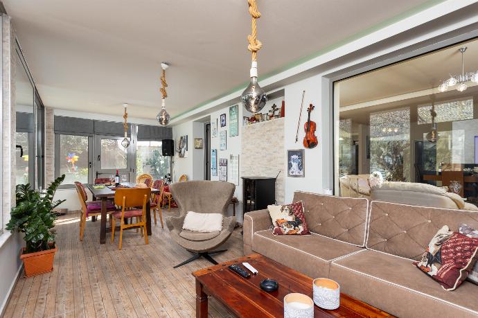 Sun room with sofa, dining area, ornamental fireplace, A/C, WiFi internet, and satellite TV . - Villa Ammos . (Photo Gallery) }}