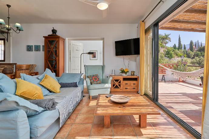 Open-plan living room with sofas, dining area, kitchen, ornamental fireplace, A/C, WiFi internet, satellite TV, and patio doors . - Villa Los Espejos De Frigiliana . (Photo Gallery) }}