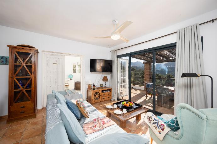 Open-plan living room with sofa, dining area, kitchen, ornamental fireplace, A/C, WiFi internet, and satellite TV . - Villa Los Espejos De Frigiliana . (Photo Gallery) }}