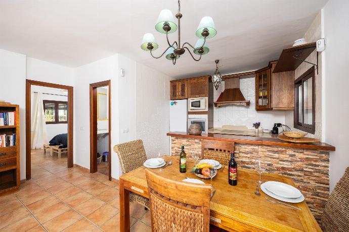 Open-plan living room with sofa, dining area, kitchen, ornamental fireplace, A/C, WiFi internet, and satellite TV . - Villa Los Espejos De Frigiliana . (Photo Gallery) }}