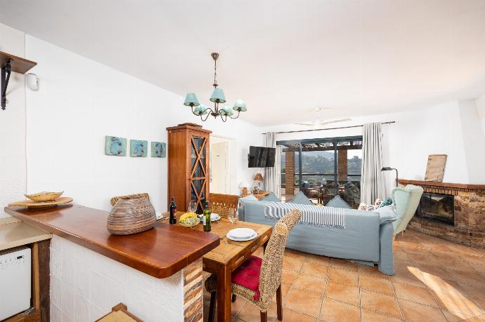 Open-plan living room with sofa, dining area, kitchen, ornamental fireplace, A/C, WiFi internet, and satellite TV . - Villa Los Espejos De Frigiliana . (Photo Gallery) }}