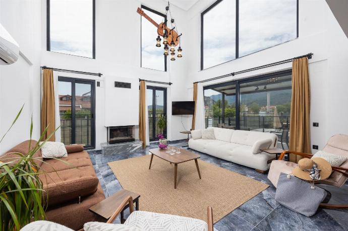 Open-plan living room with sofas, dining area, kitchen, ornamental fireplace, A/C, WiFi internet, and satellite TV . - Villa Wonder . (Photo Gallery) }}