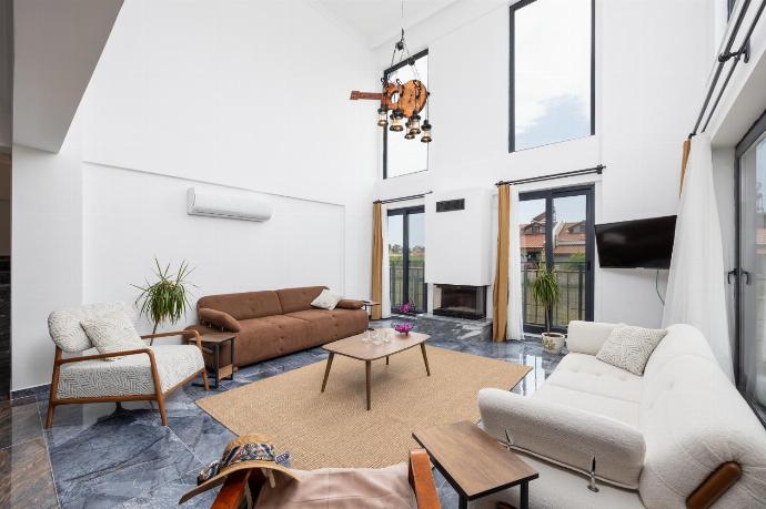 Open-plan living room with sofas, dining area, kitchen, ornamental fireplace, A/C, WiFi internet, and satellite TV . - Villa Wonder . (Photo Gallery) }}