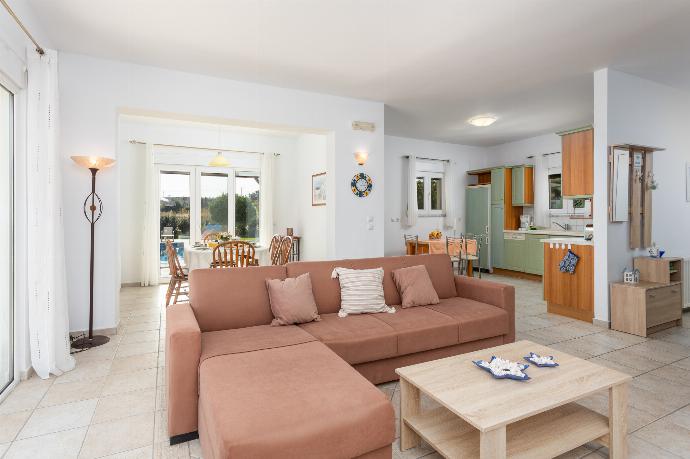 Open-plan living room with sofa, dining area, kitchen, ornamental fireplace, A/C, WiFi internet, and satellite TV . - Hermione Villa . (Photo Gallery) }}