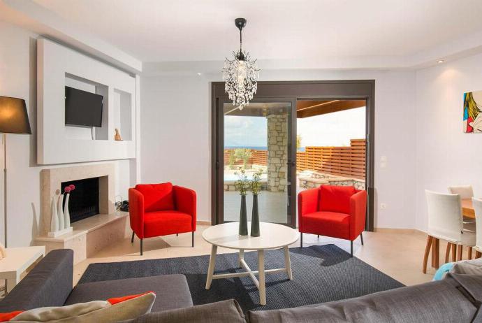Open plan living room with comfortable sofas, A/C, WiFi, ornamental fireplace, patio doors, TV. . - Villa Ira . (Galleria fotografica) }}