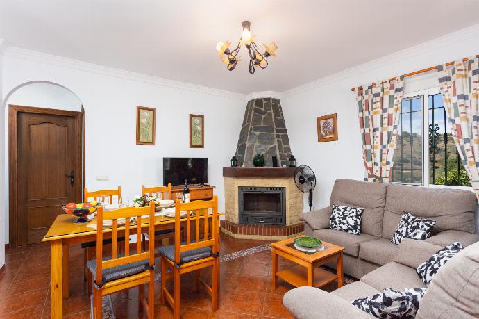 Open-plan living room with sofas, dining area, kitchen, ornamental fireplace, WiFi internet, and satellite TV . - Villa Conchi Frigiliana . (Photo Gallery) }}