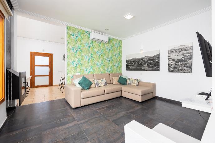Open-plan living room with sofa, dining area, kitchen, ornamental fireplace, A/C, WiFi internet, and satellite TV . - Villa Ariel . (Photo Gallery) }}