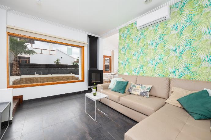 Open-plan living room with sofa, dining area, kitchen, ornamental fireplace, A/C, WiFi internet, and satellite TV . - Villa Ariel . (Photo Gallery) }}