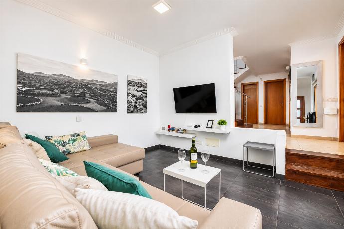 Open-plan living room with sofa, dining area, kitchen, ornamental fireplace, A/C, WiFi internet, and satellite TV . - Villa Ariel . (Galleria fotografica) }}