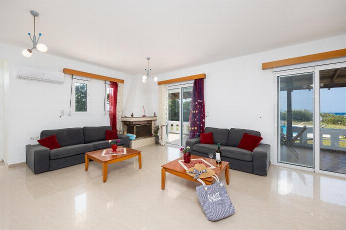 Living room with sofas, dining area, ornamental fireplace, A/C, WiFi internet, and satellite TV . - Villa Sunset . (Photo Gallery) }}