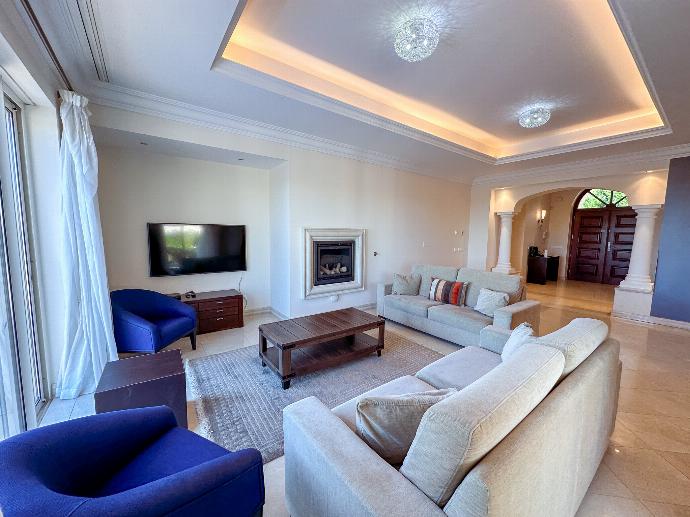 Open-plan living room with comfortable sofas, TV, ornamental fireplace, patio doors . - Villa Monte Rei . (Photo Gallery) }}
