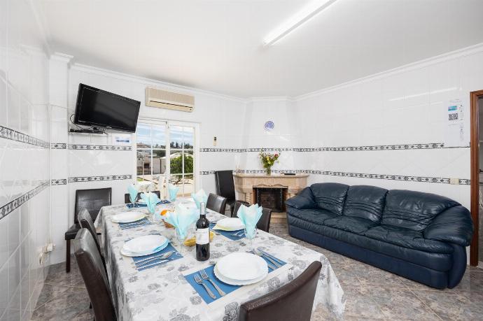 Dining area with sofa, ornamental fireplace, A/C, and TV . - Villa Marlene . (Photo Gallery) }}
