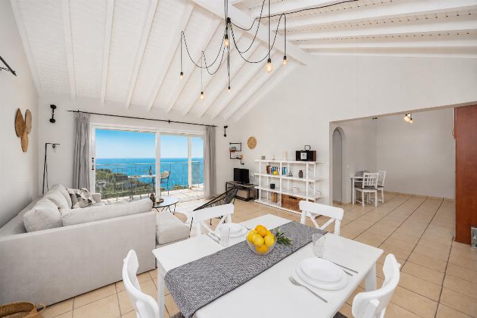 Open-plan living room with sofa, dining area, kitchen, A/C, WiFi internet, satellite TV, and sea views . - Villa Jasmine . (Photo Gallery) }}
