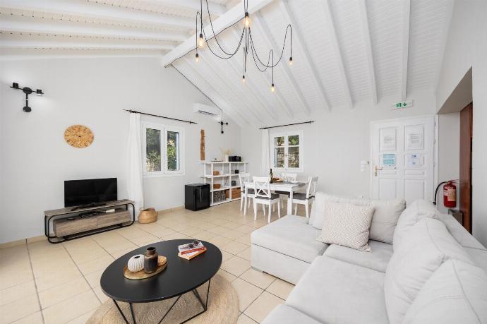 Open-plan living room with sofa, dining area, kitchen, A/C, WiFi internet, satellite TV, and sea views . - Villa Bougainvillea . (Photo Gallery) }}
