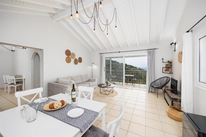 Open-plan living room with sofa, dining area, kitchen, A/C, WiFi internet, satellite TV, and sea views . - Villa Bougainvillea . (Photo Gallery) }}