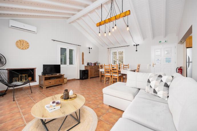 Open-plan living room with sofa, dining area, kitchen, ornamental fireplace, A/C, WiFi internet, satellite TV, and sea views . - Villa Gardenia . (Photo Gallery) }}