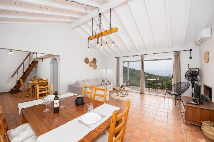 Open-plan living room with sofa, dining area, kitchen, ornamental fireplace, A/C, WiFi internet, satellite TV, and sea views . - Villa Gardenia . (Photo Gallery) }}