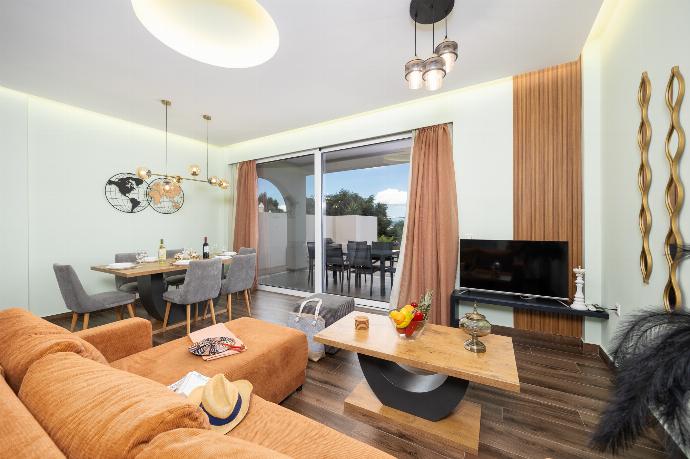 Open-plan living room with sofa, dining area, kitchen, A/C, WiFi internet, satellite TV, and sea views . - Villa Alora . (Photo Gallery) }}