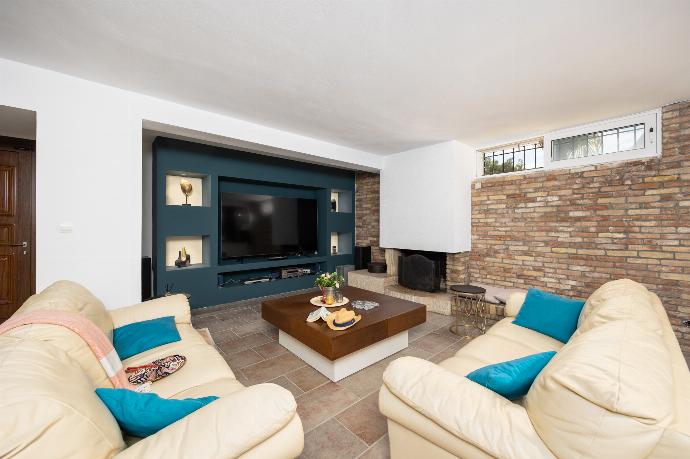 Open-plan living room on ground floor with sofas, dining area, bar area, ornamental fireplace, gym area, WiFi internet, and satellite TV . - Villa Noulia . (Photo Gallery) }}