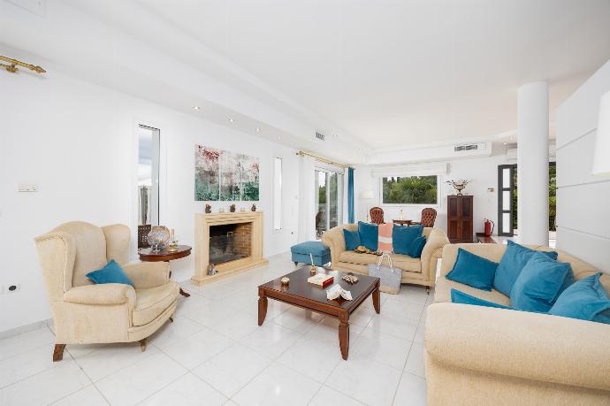 Open-plan living room on first floor with sofas, dining area, kitchen, ornamental fireplace, A/C, and WiFi internet . - Villa Noulia . (Photo Gallery) }}